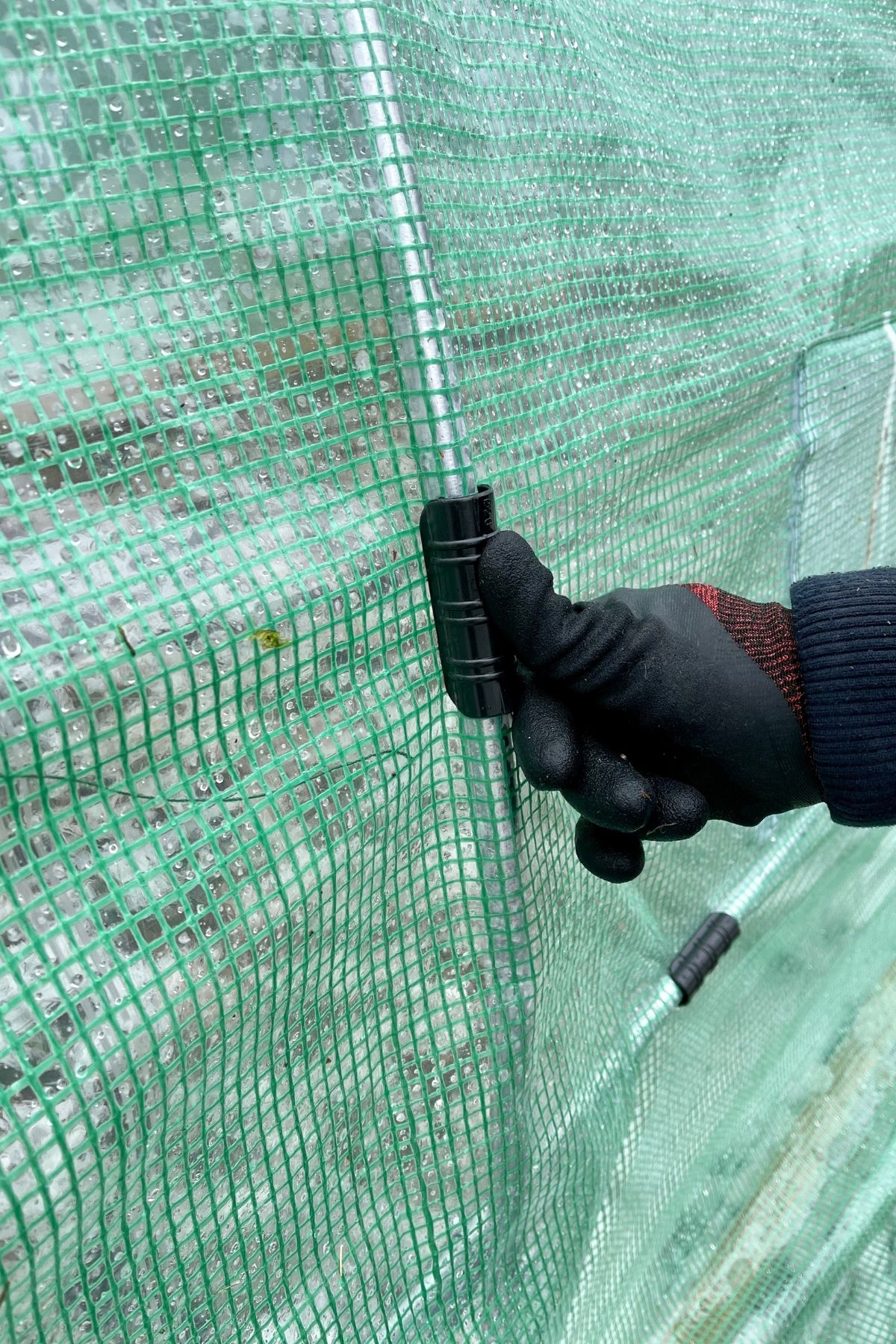 Gloved hand putting clamp onto pole