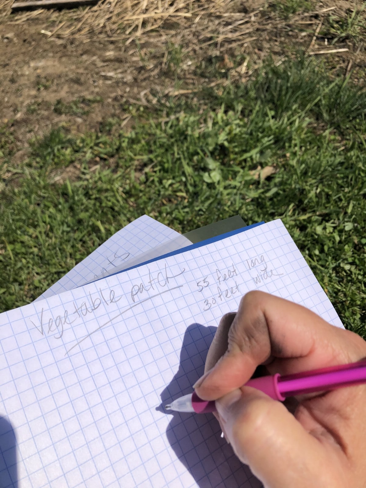 Using a graph paper notebook for planning a garden layout.