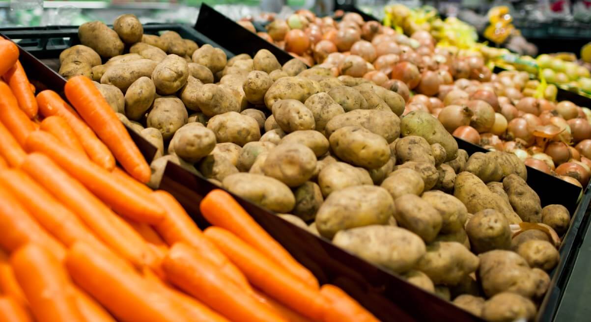 bin of potatoes in store next to carrots
