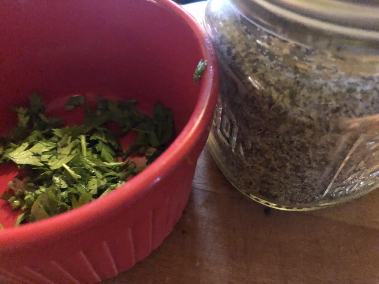 dried seasoning mix next to fresh chopped herbs
