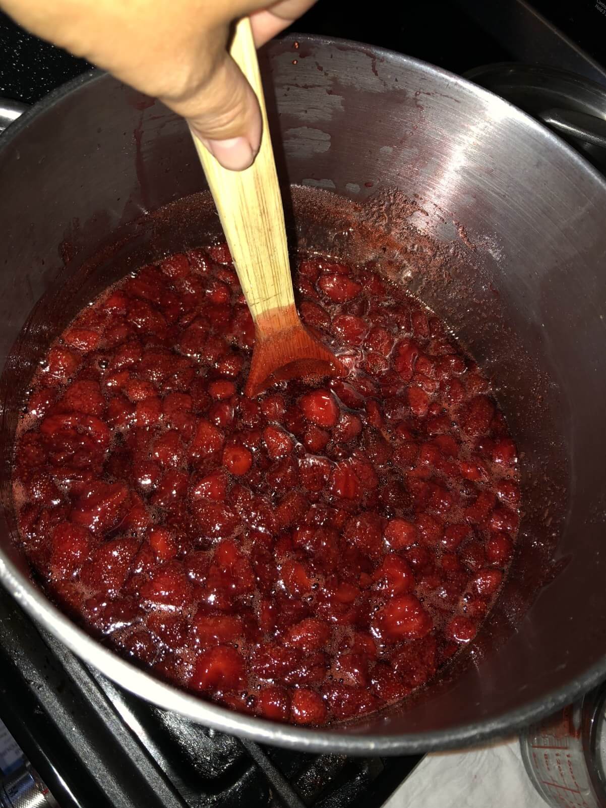 stirring sugar into strawberry jam