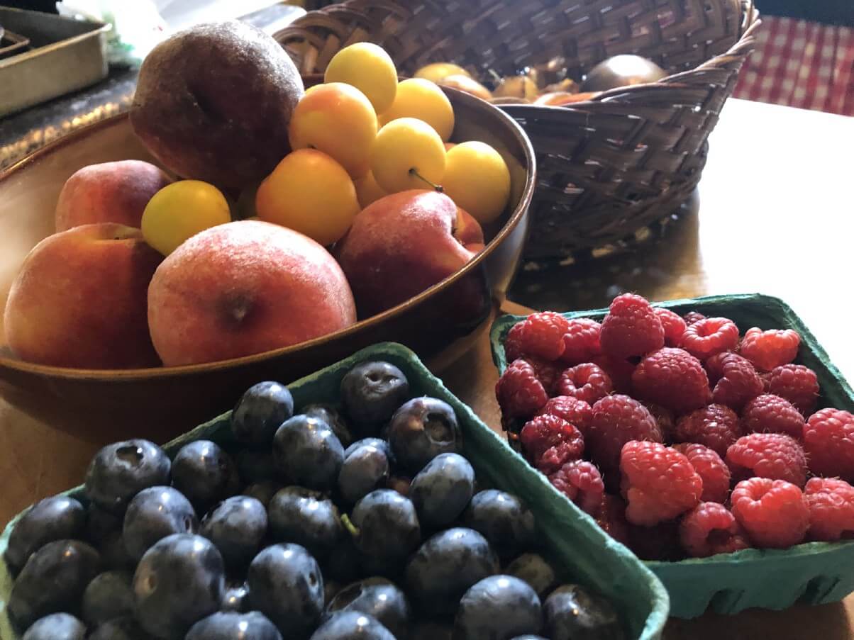 bluberries, raspberries, tomatoes, and peaches ready to preserve