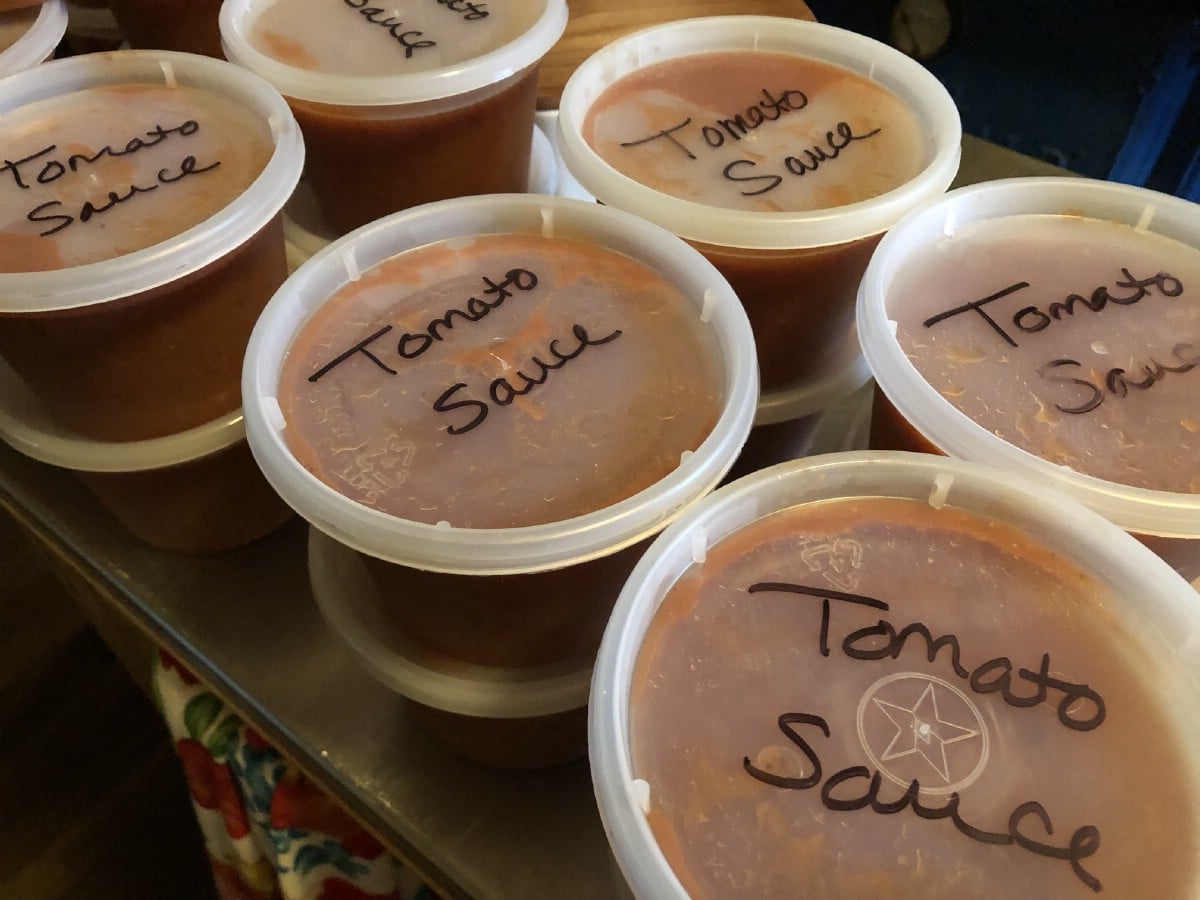 tomato sauce packaged in reusable deli containers for freezing