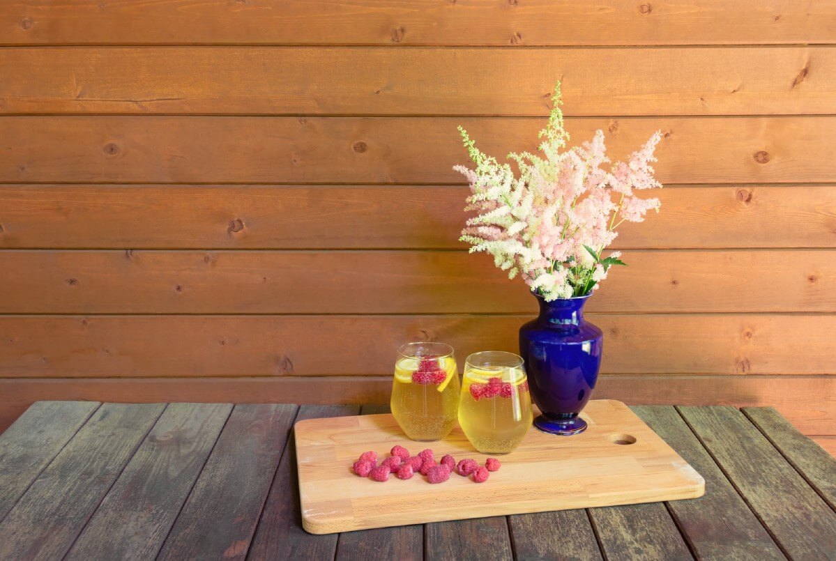 two summer drinks on a tray next to a vase of cut Astilbe flowers