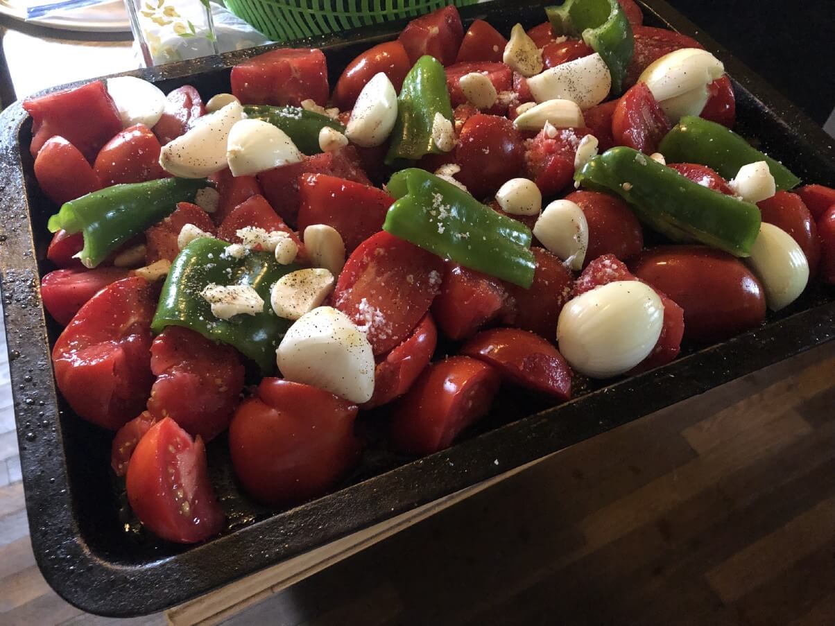 roasting pan with tomatoes, peppers, and garlic