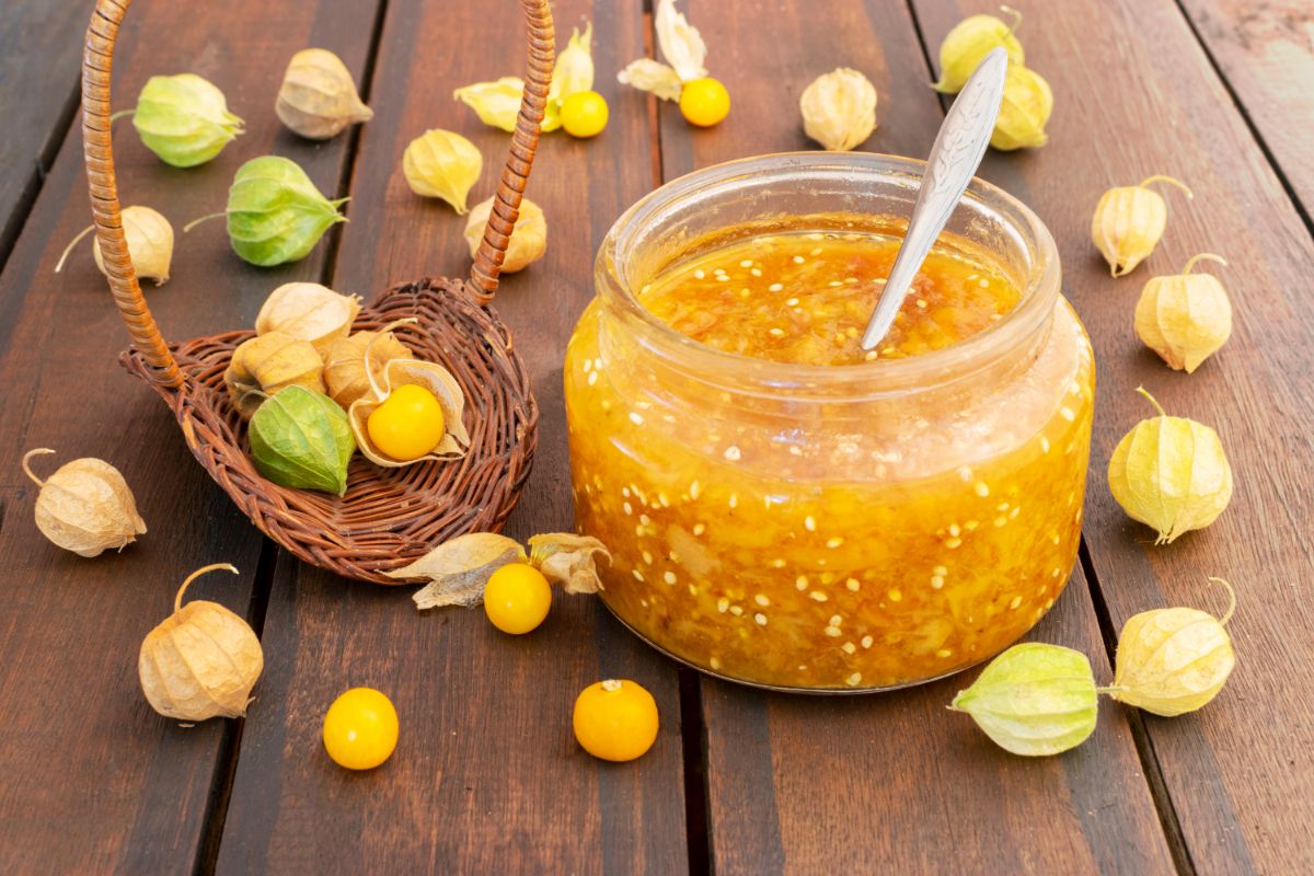 ground cherries scattered around a jar of ground cherry jam