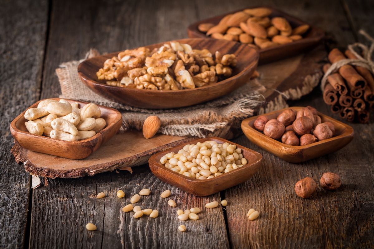 wooden square bowls filled with different types of tree nuts