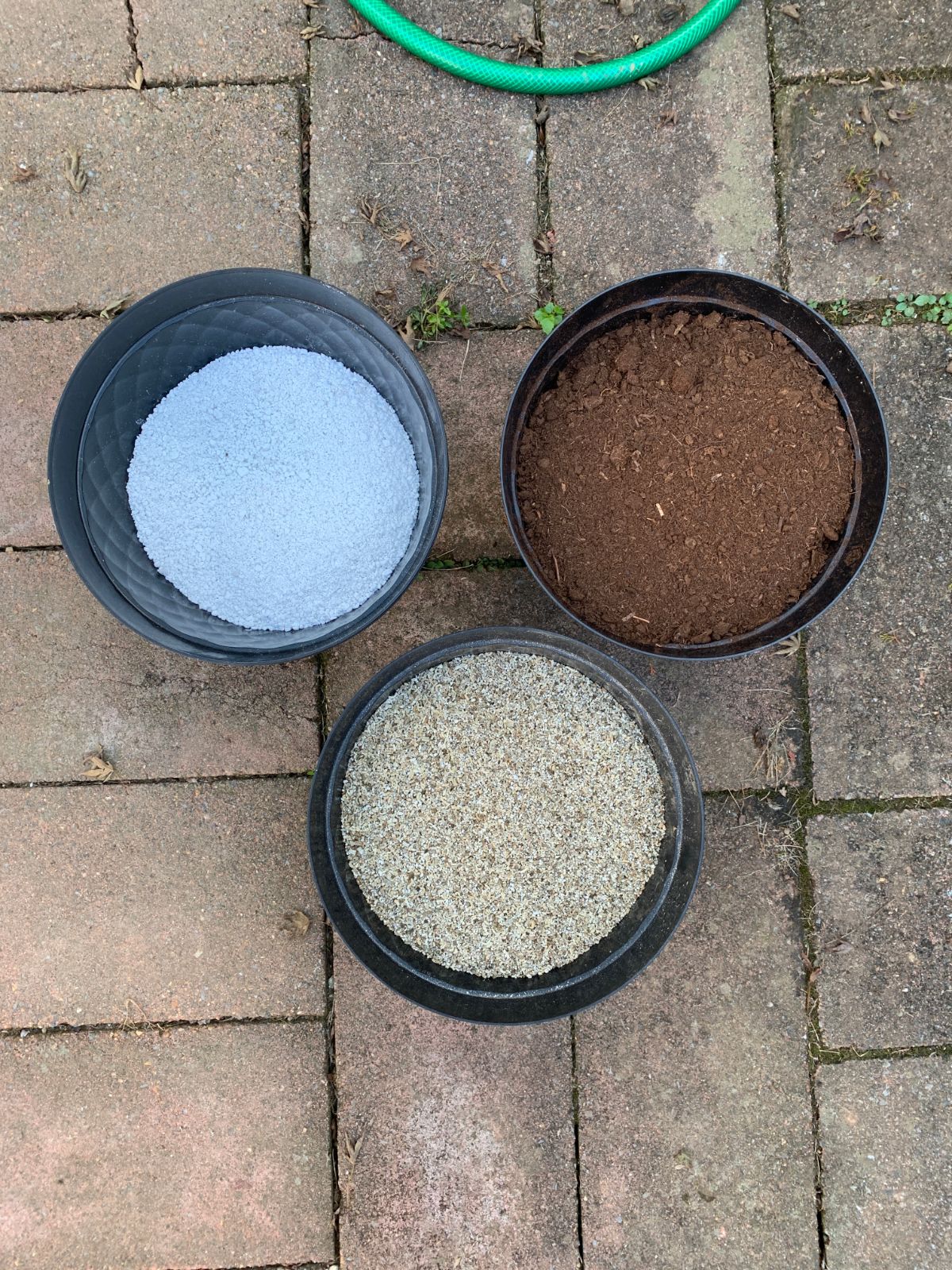 three large buckets filled with garden soil amendments