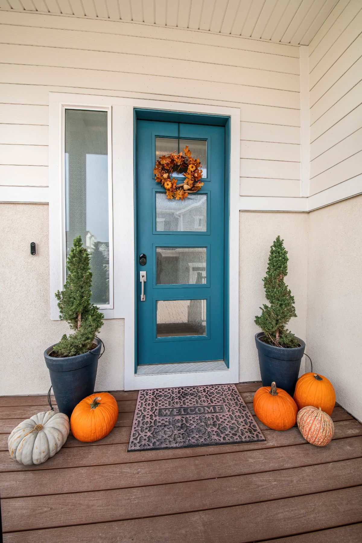 Two spiral shaped topiary plants flanking a front entry door