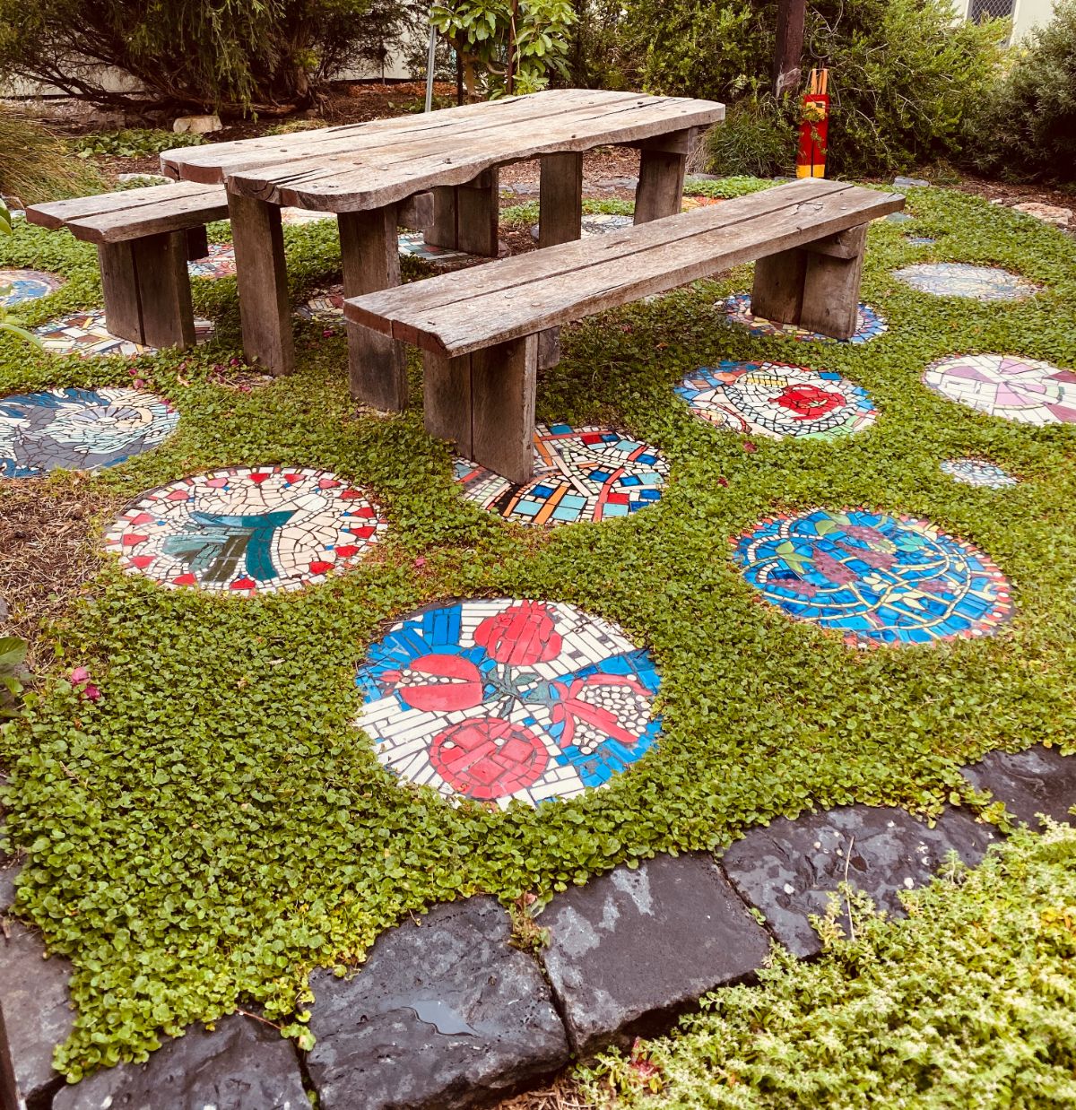 An outdoor dining area laid with homemade mosaic stepping stones