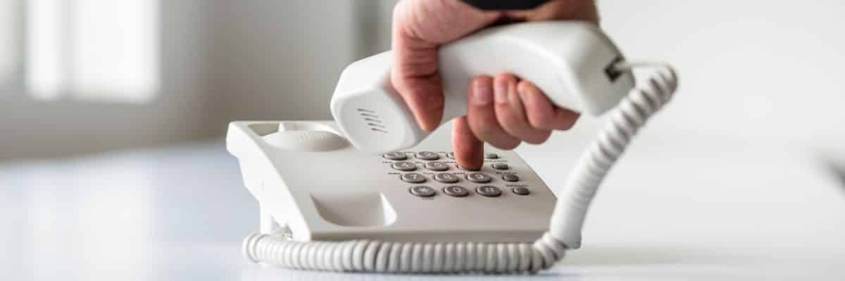 A person picking up a phone to call a rat control service