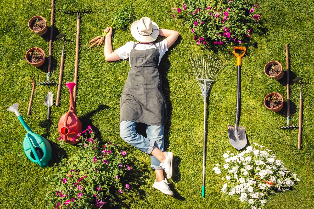 A woman relaxing amongst her garden and favorite garden tools