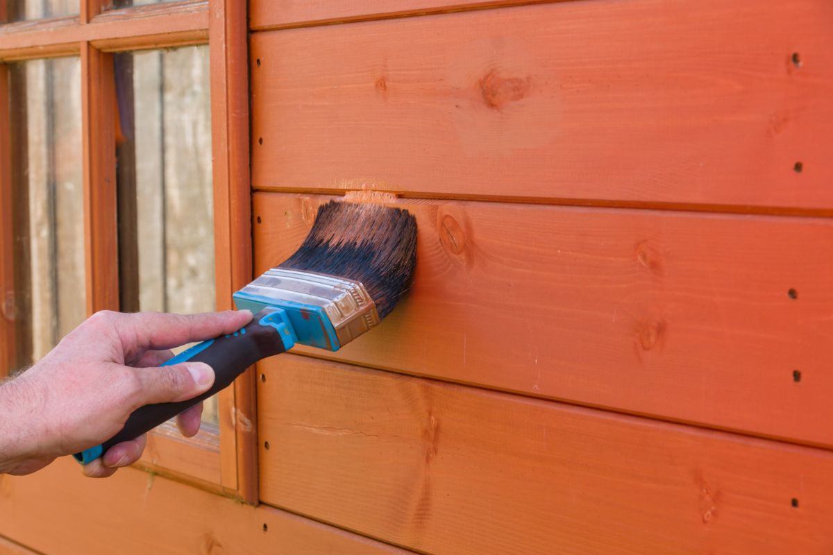 Applying weather proofing oil to a garden shed