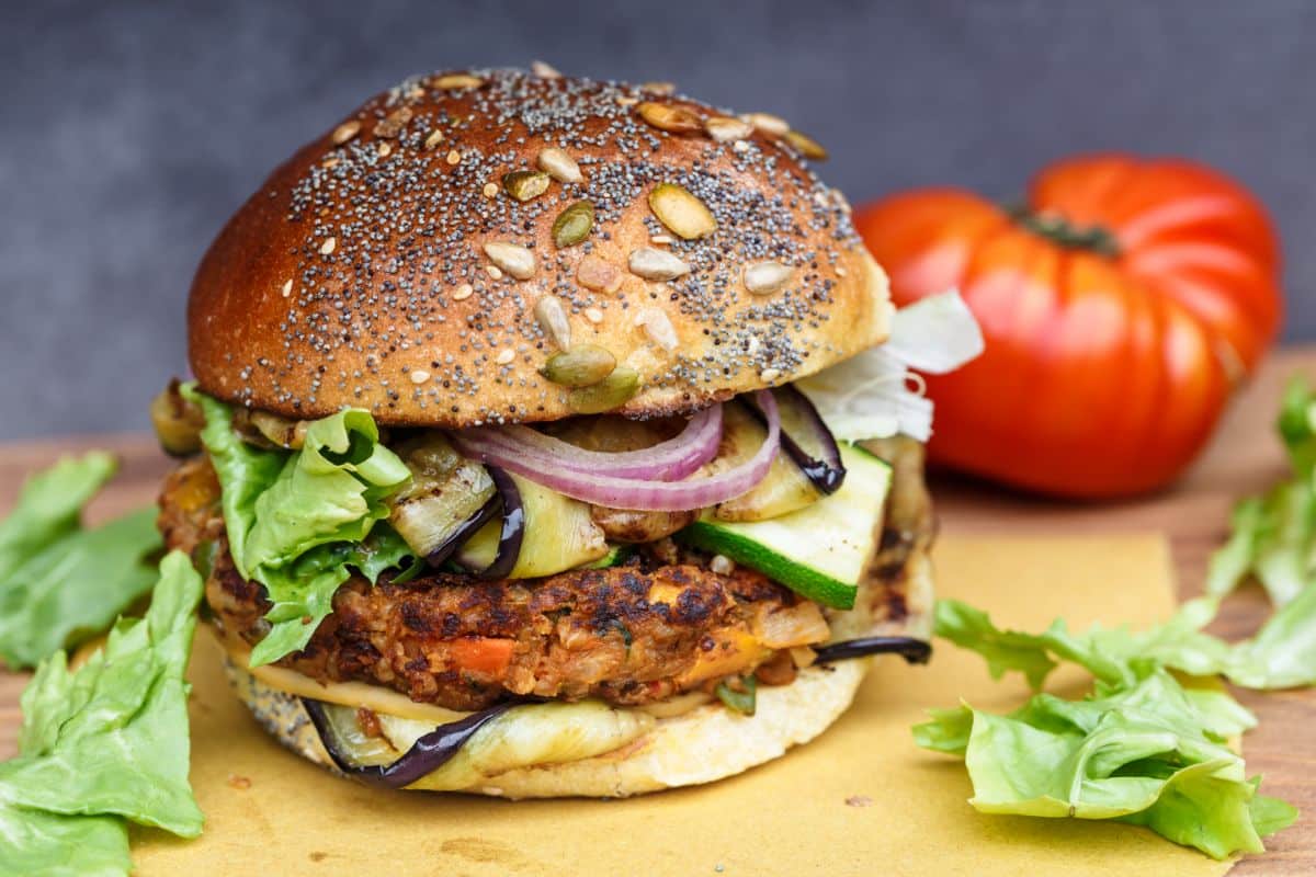 A burger with slices of cooked zucchini 