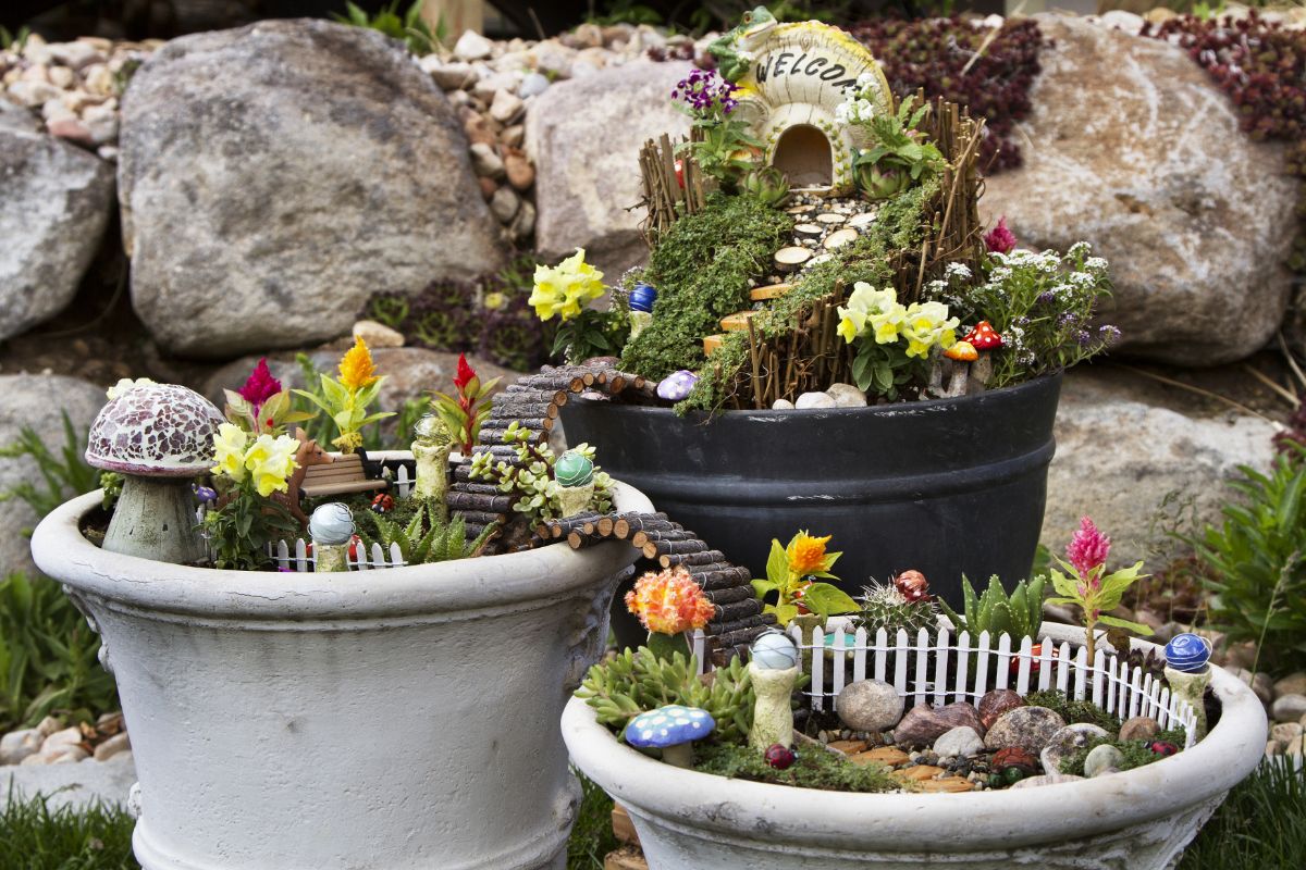 A three-tiered potted fairy garden with log paths connecting each
