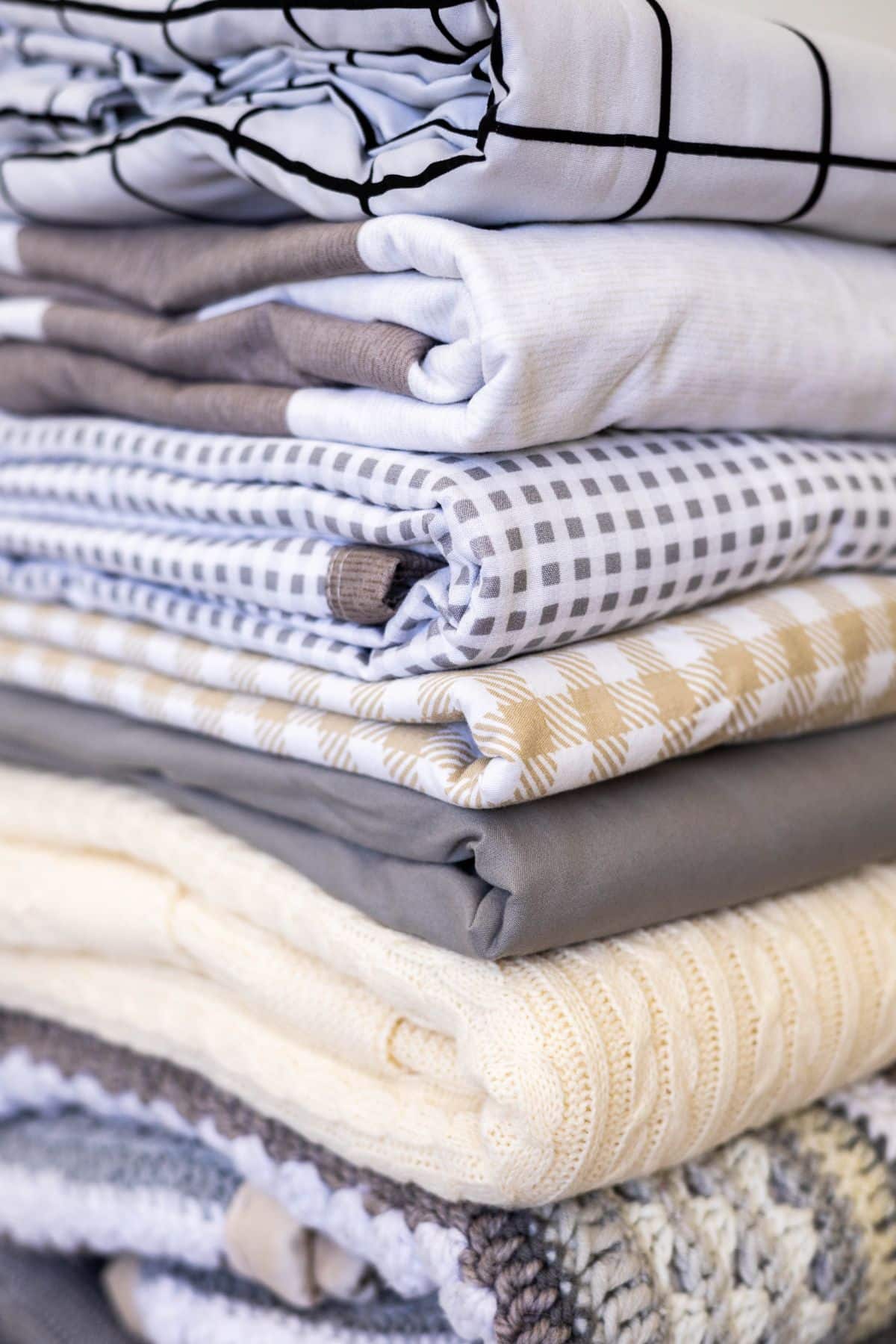 A stack of old folded bed linens collected for covering plants to protect from frost