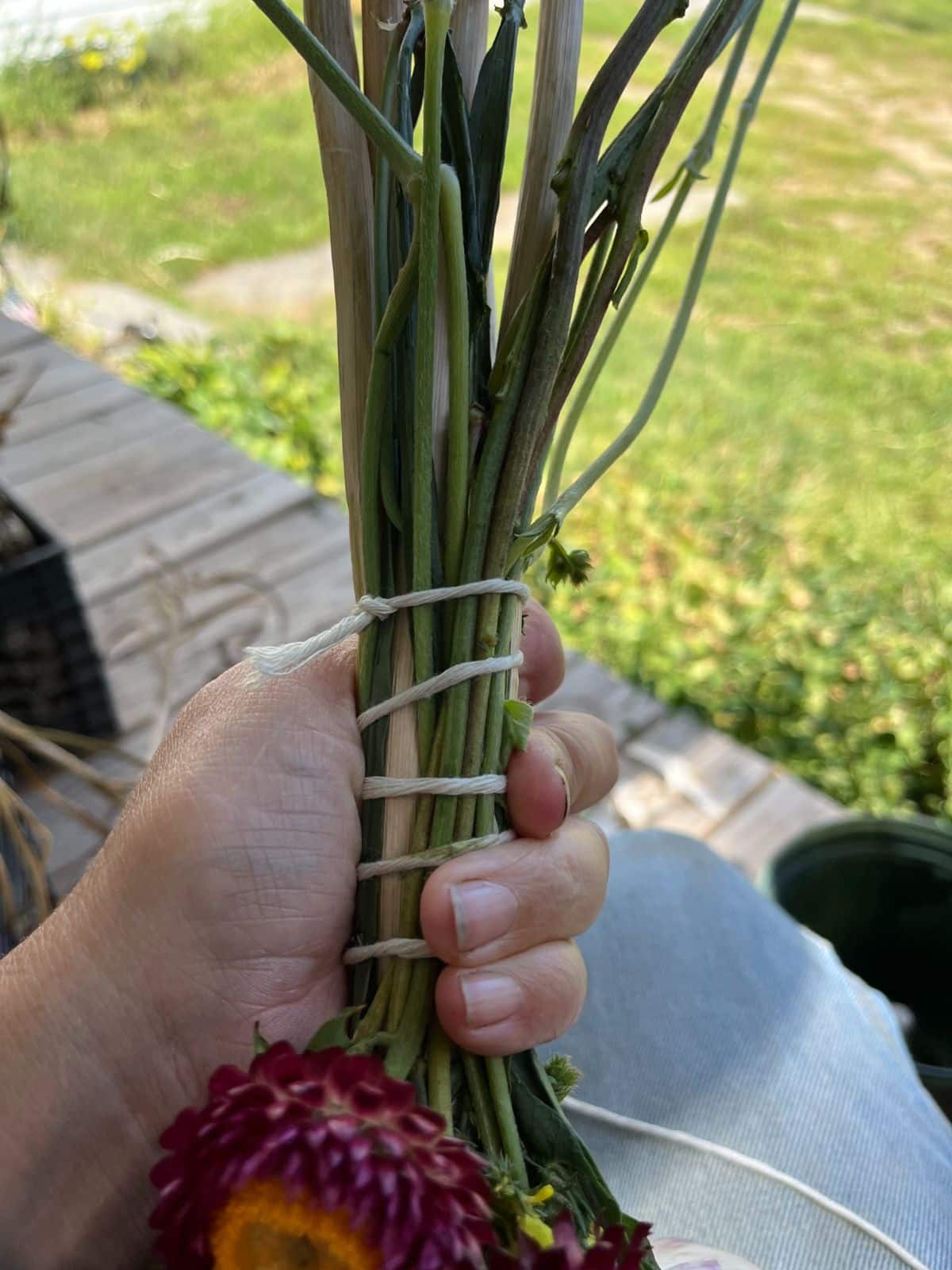 Wrapping the stems of the garlic and dried flowers with white twine