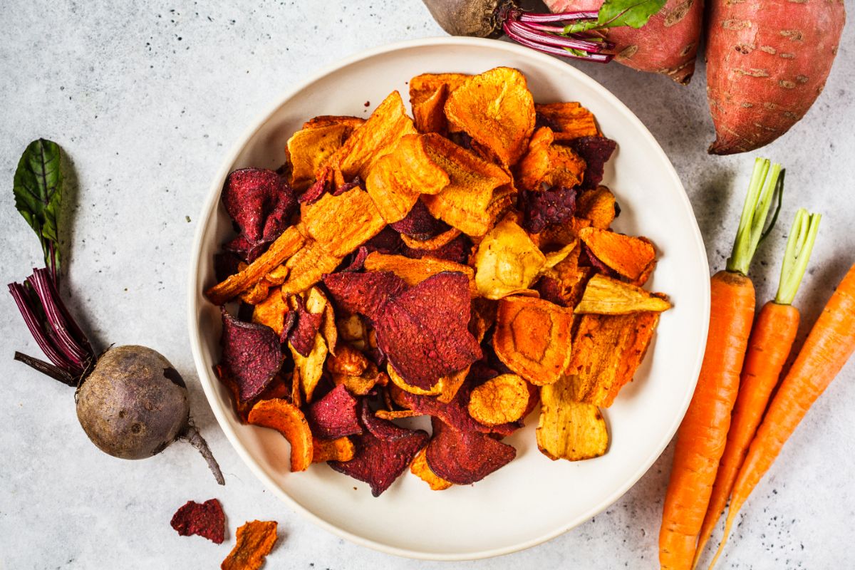 Colorful carrot chips sit in a bowl after dehydrating