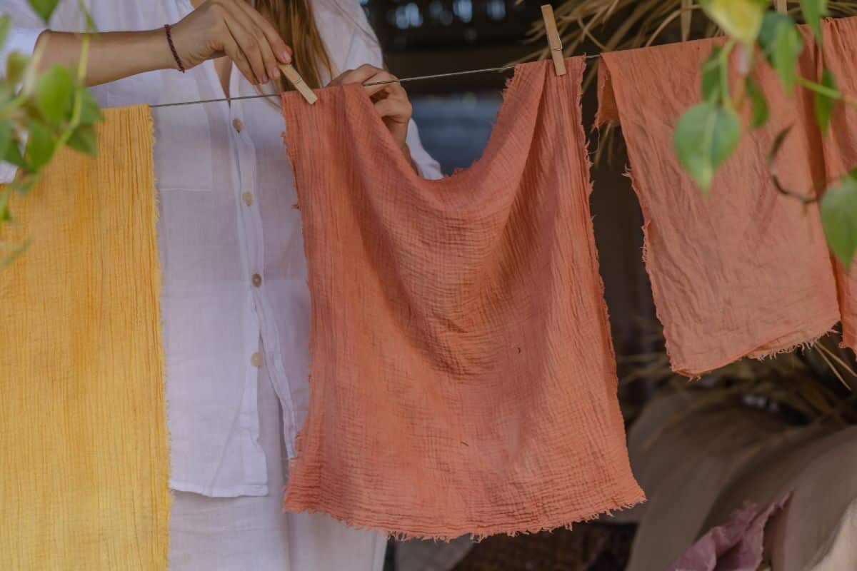 A home dye maker hangs sheets of cloth dyed brown with natural plant dyes