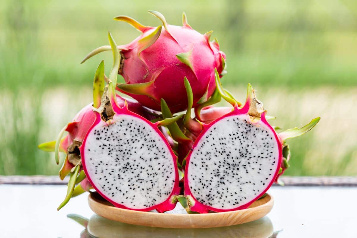 A dragonfruit is cut in half revealing its edible interior