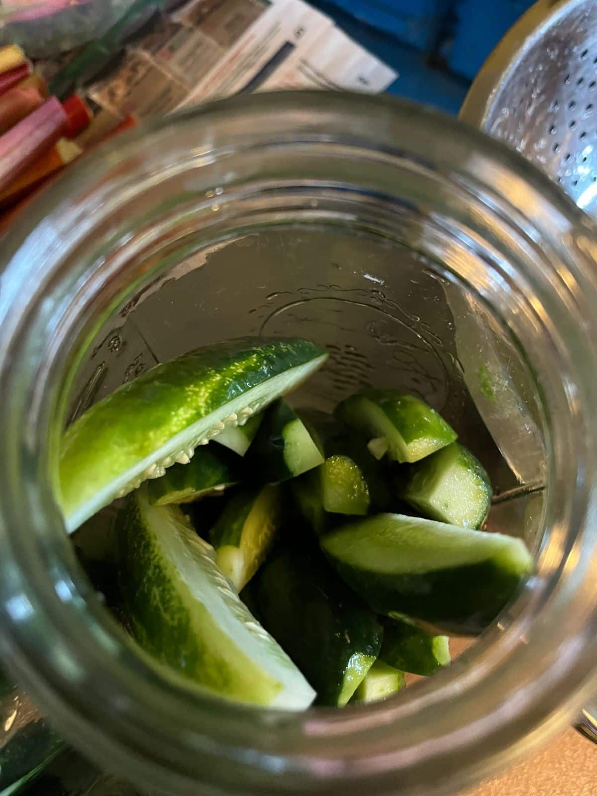 Cut cucumbers packed into a jar for pickling