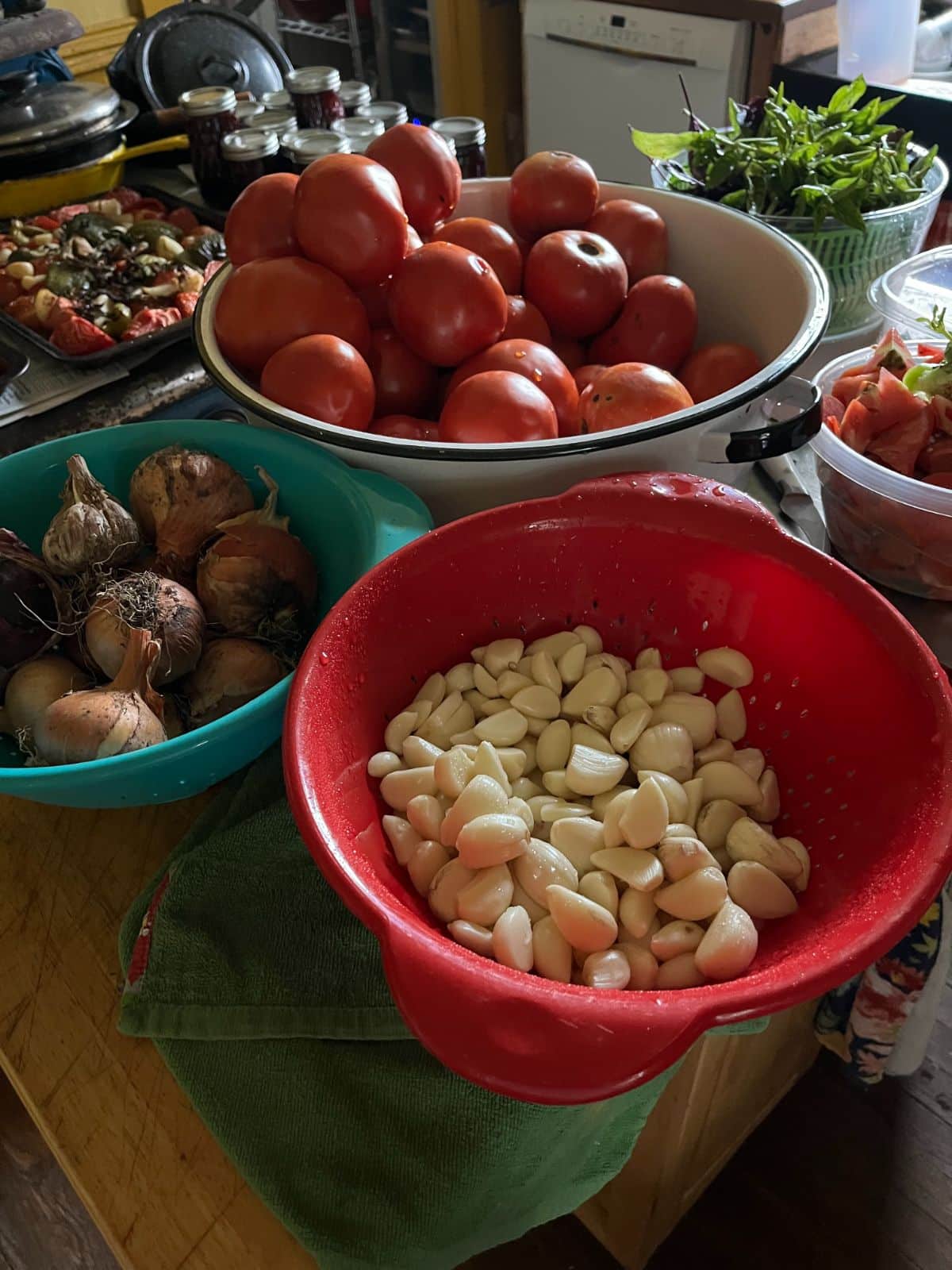 Peeled garlic and vegetables being prepped for roasted tomato sauce