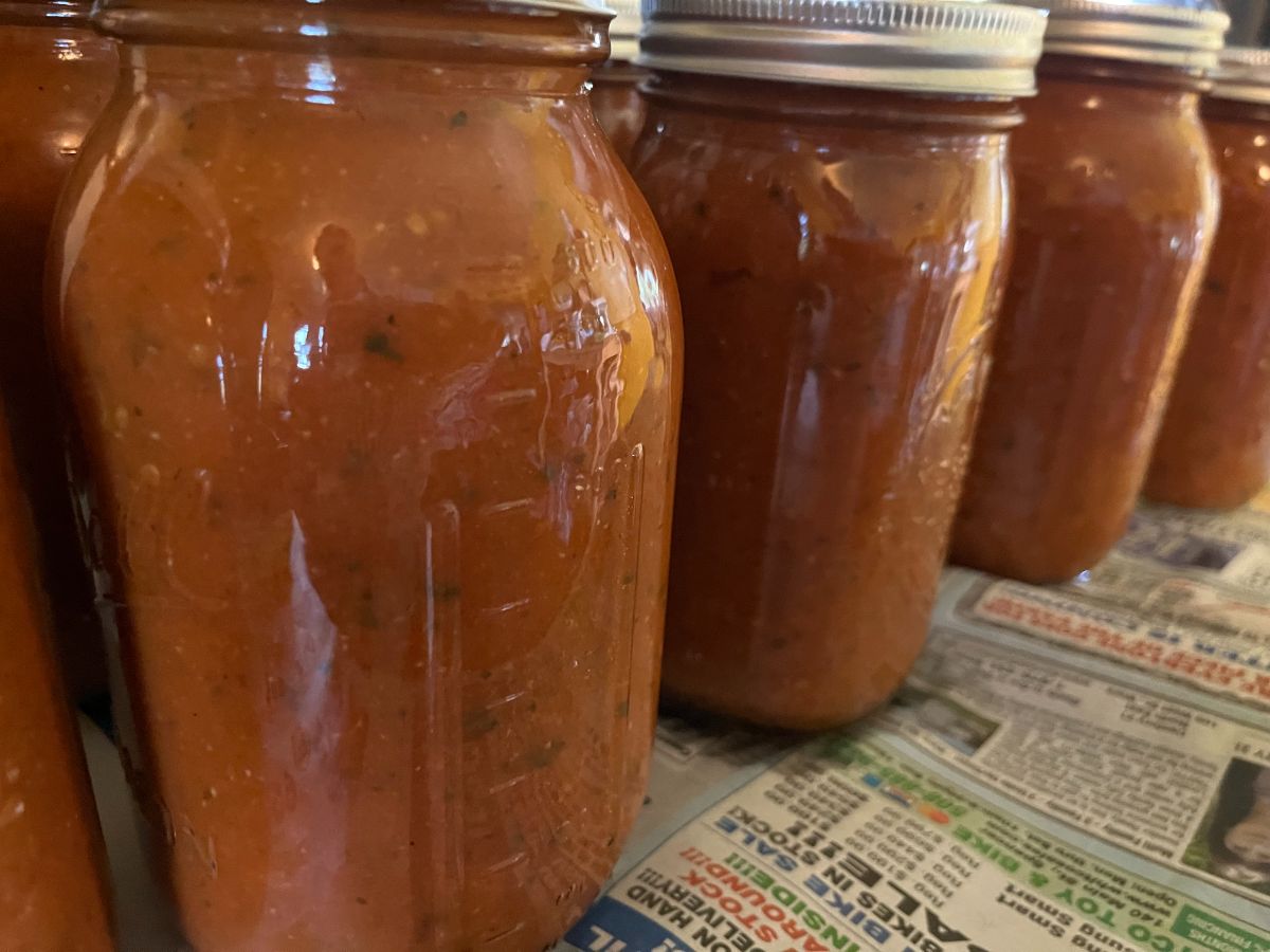 Wide mouth canning jars filled with tomato sauce