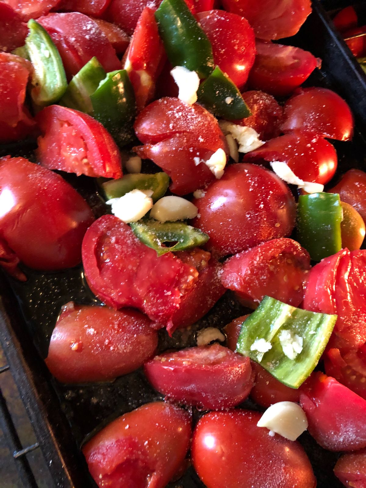 A pan of prepared tomatoes, peppers, and garlic for making tomato sauce