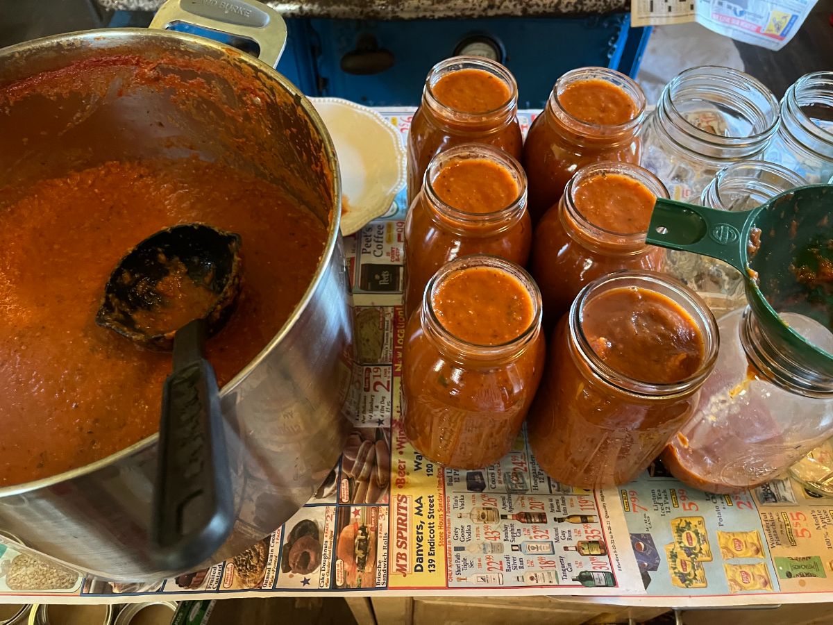 Jars being filled with roasted tomato sauce