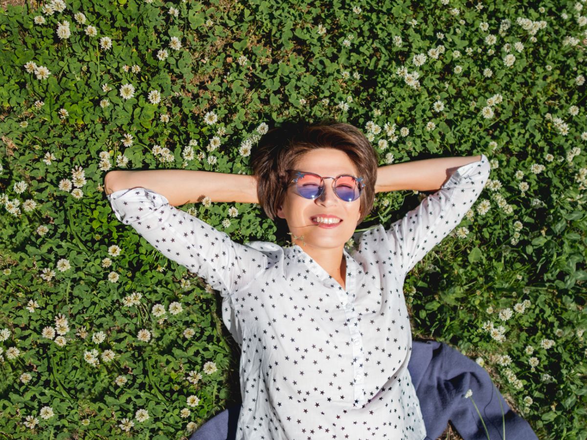 A woman enjoys the sun on her alternative grass clover lawn