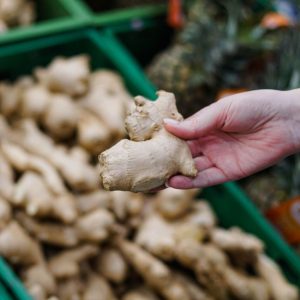 A woman is holding freshly harvested ginger.