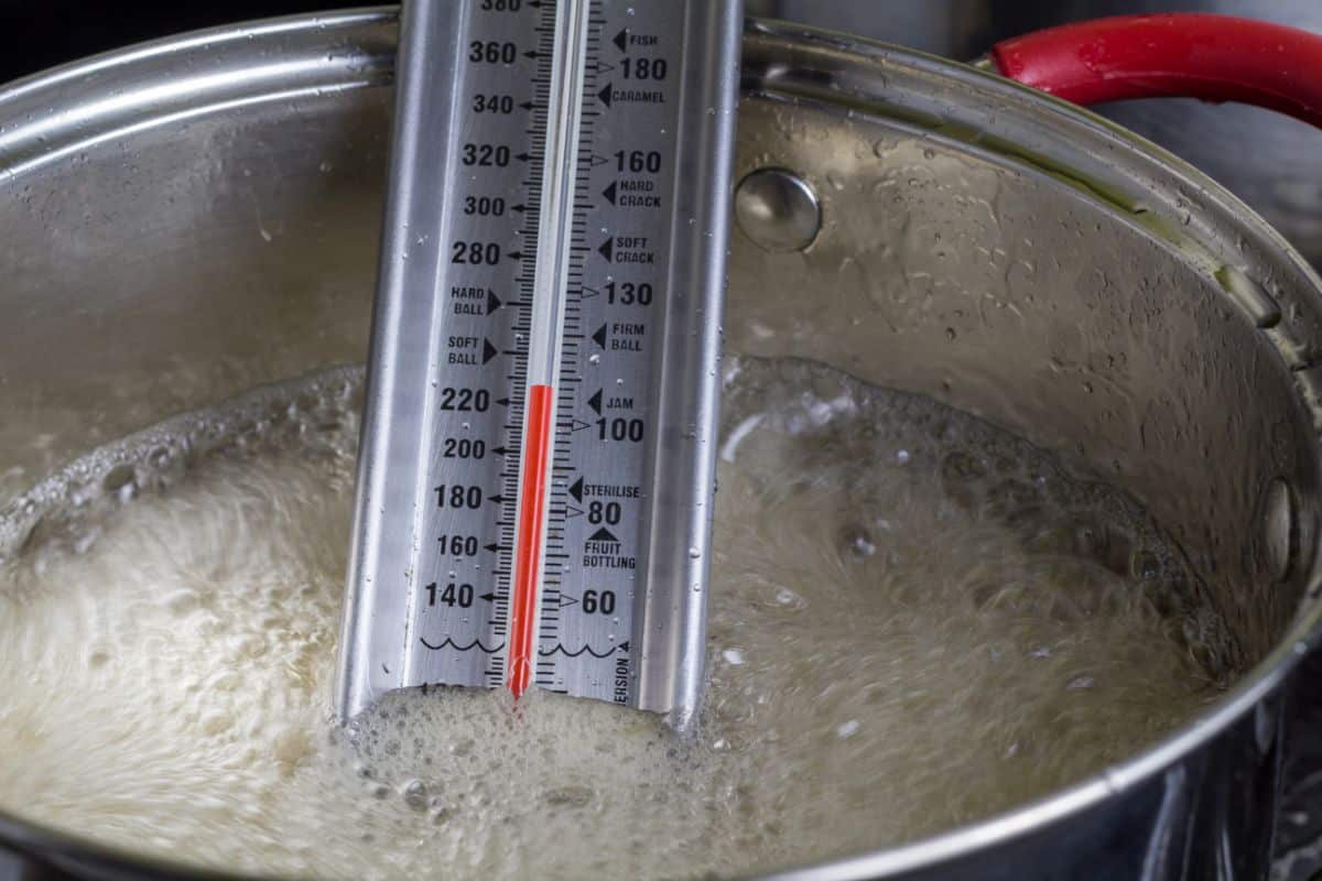 A thermometer in a pot of maple syrup 