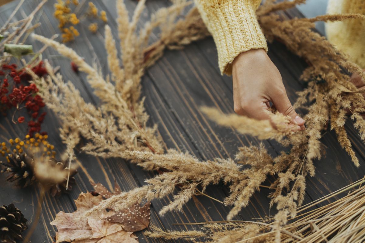 A woman making a wreath from grains and natural foraged items
