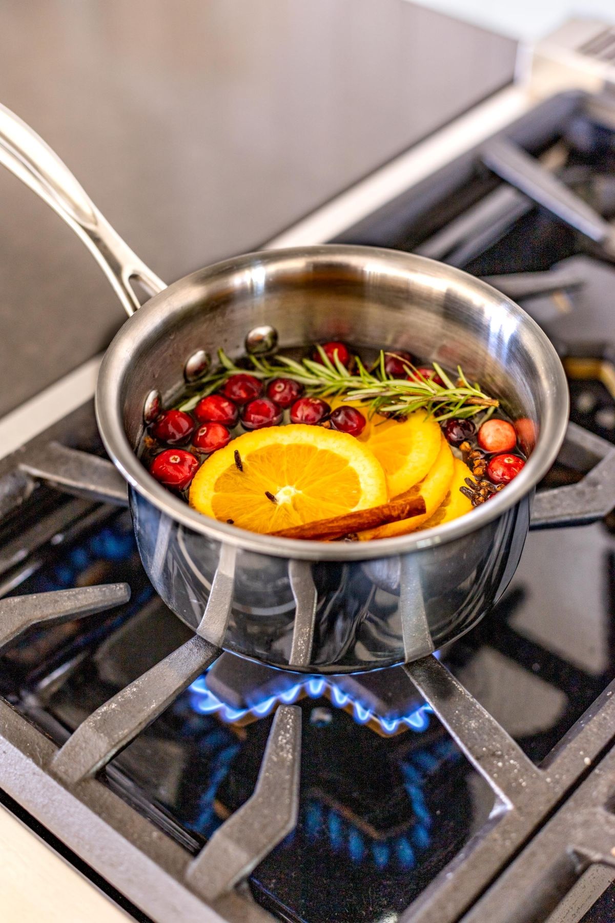 A simmer pot with herbs and citrus on a stove