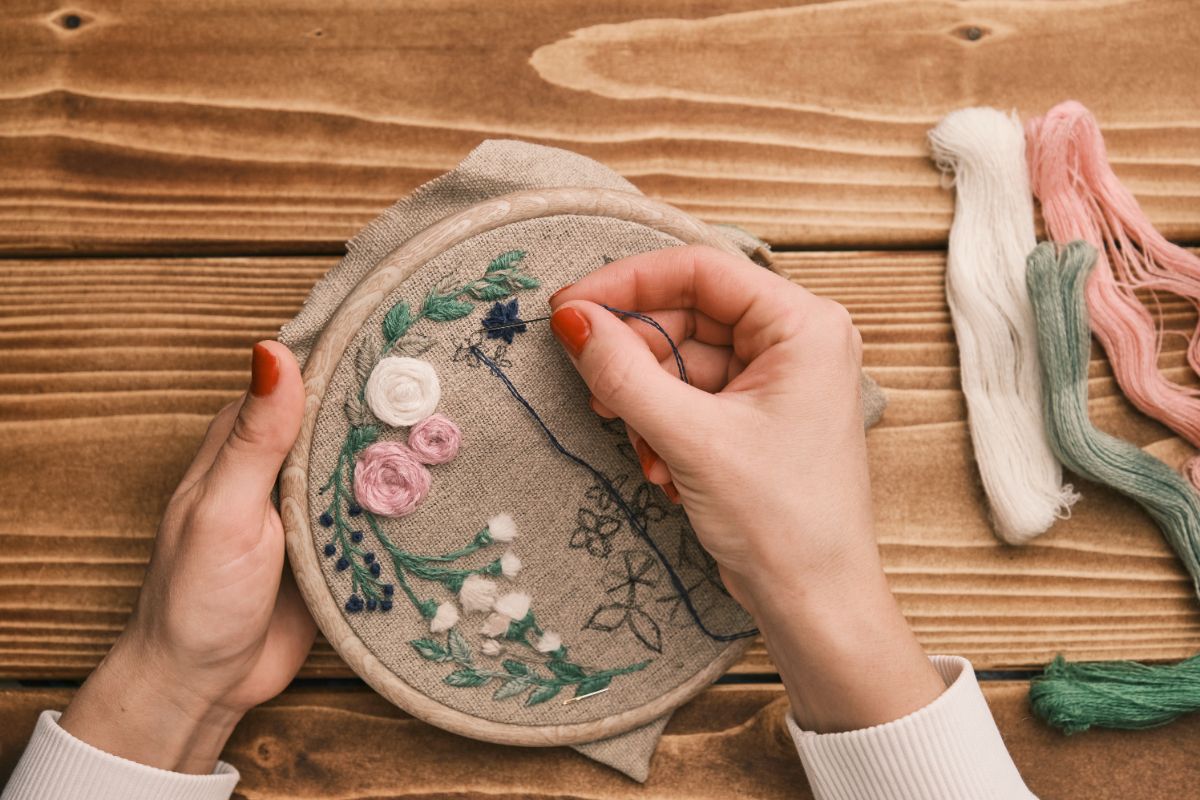 A crafter creating a flowered embroidery piece