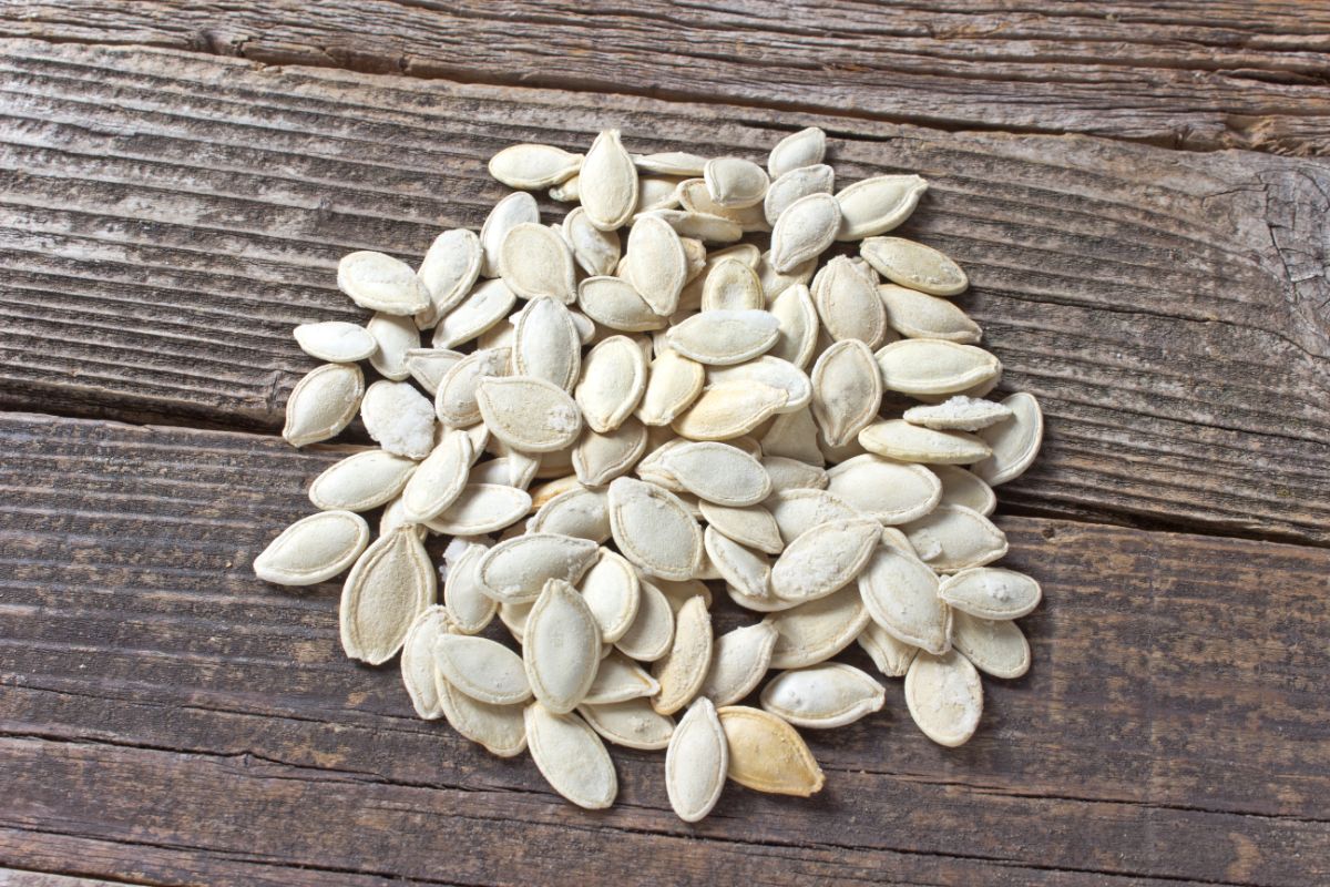 Large pumpkin seeds on a table waiting to be planted.