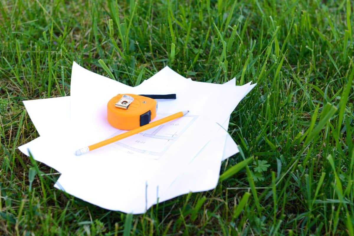 A gardener sits in grass planning rotational garden designs