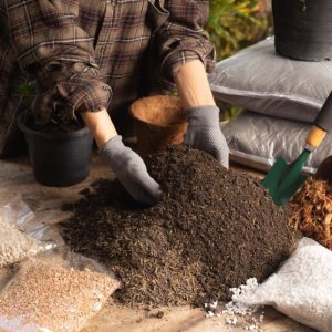 A gardener mixing potting soil on a table.