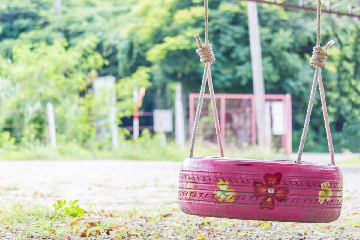 A pretty pink flowered painted tire swing