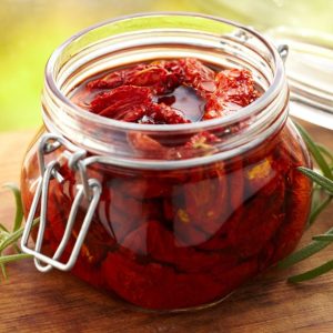 Sundried tomatoes with olive oil in a glass jar.