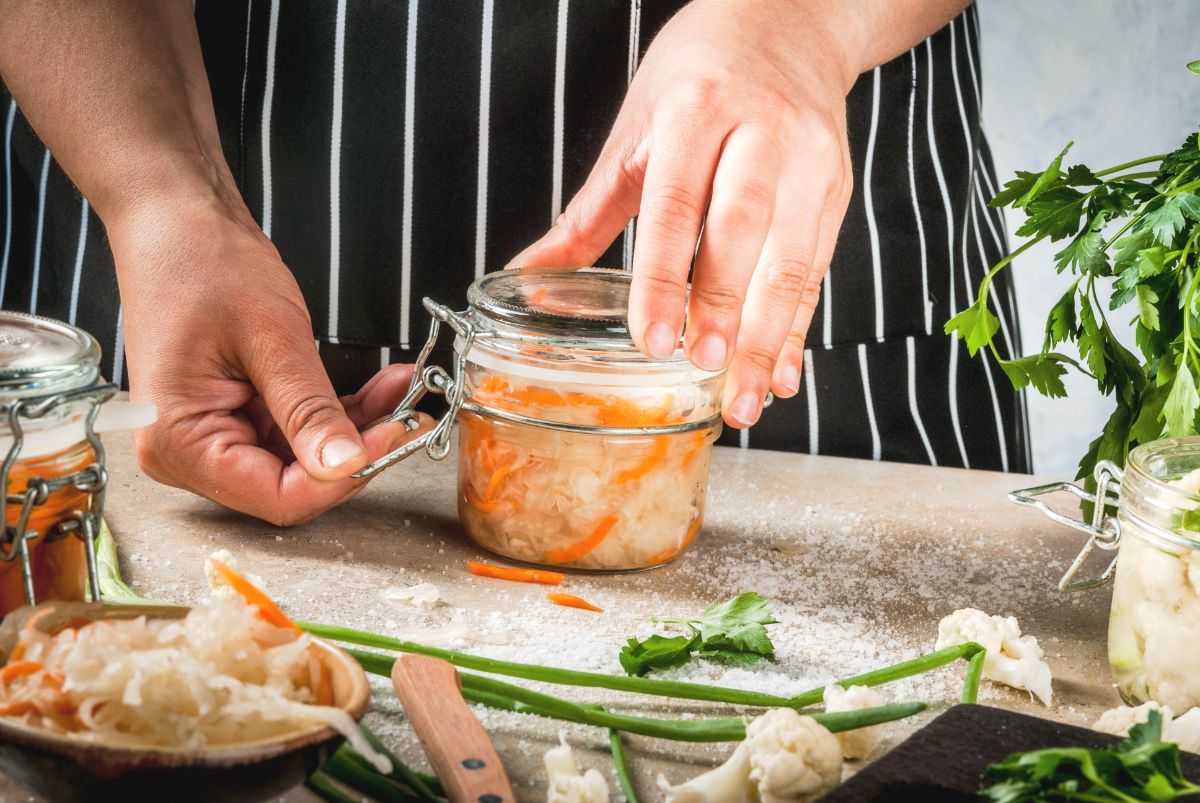 A person latching a jar of sauerkraut