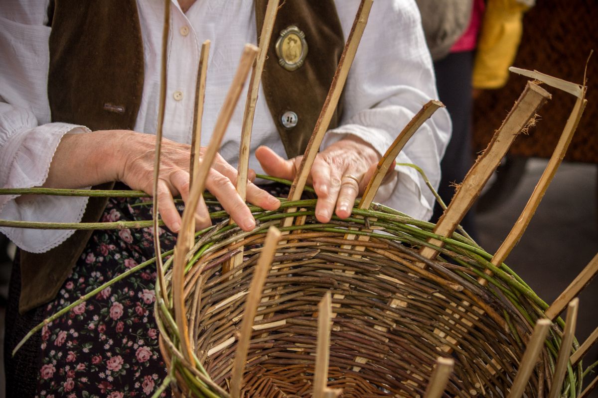 A person working on a hand-woven basket