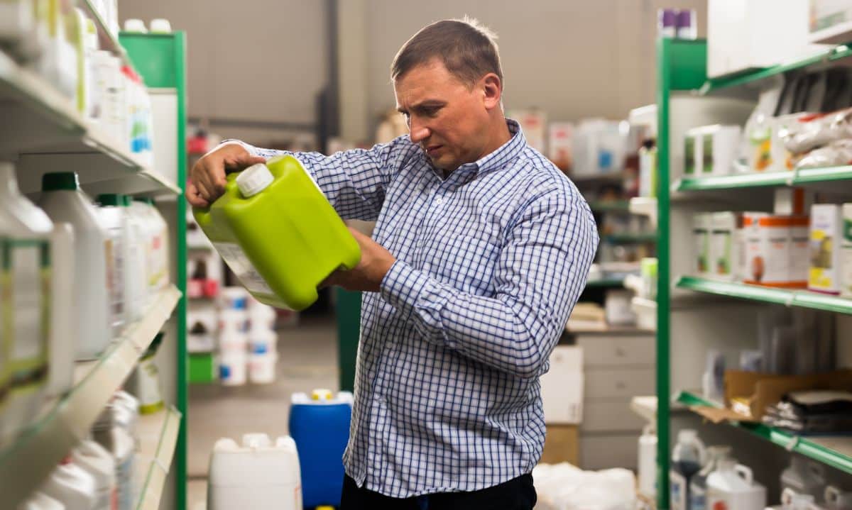 A man reads an organic pesticide label