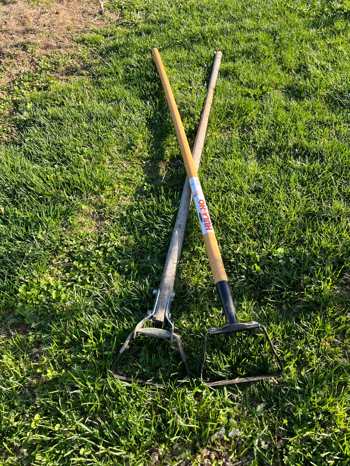 Two weeding hula hoes on the ground