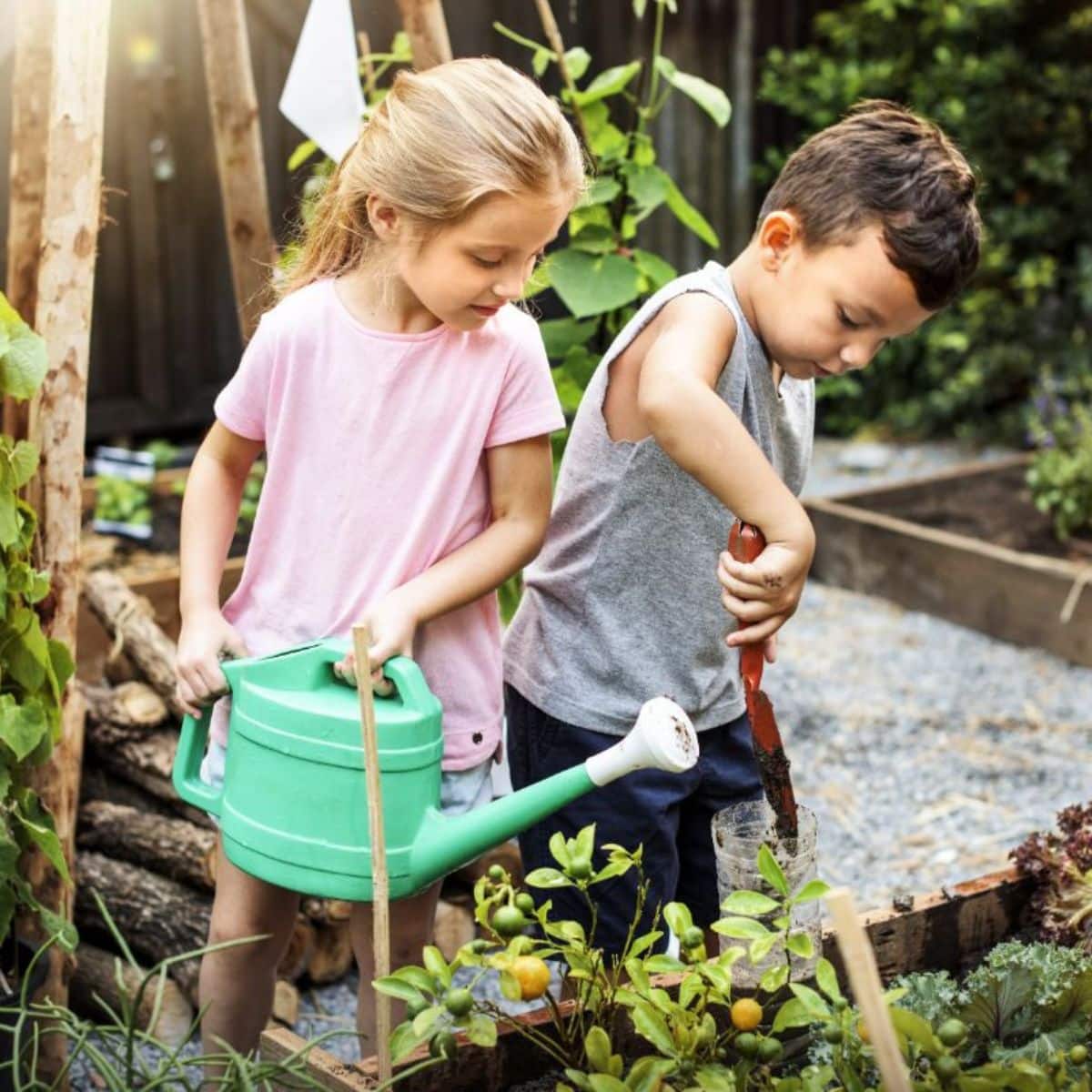 Two kids are working in a backyard garden.