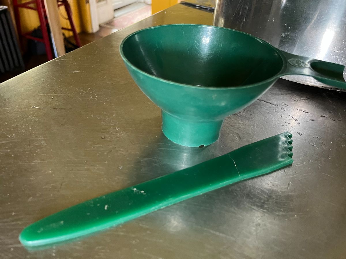 Green canning funnel behind a spatula tool