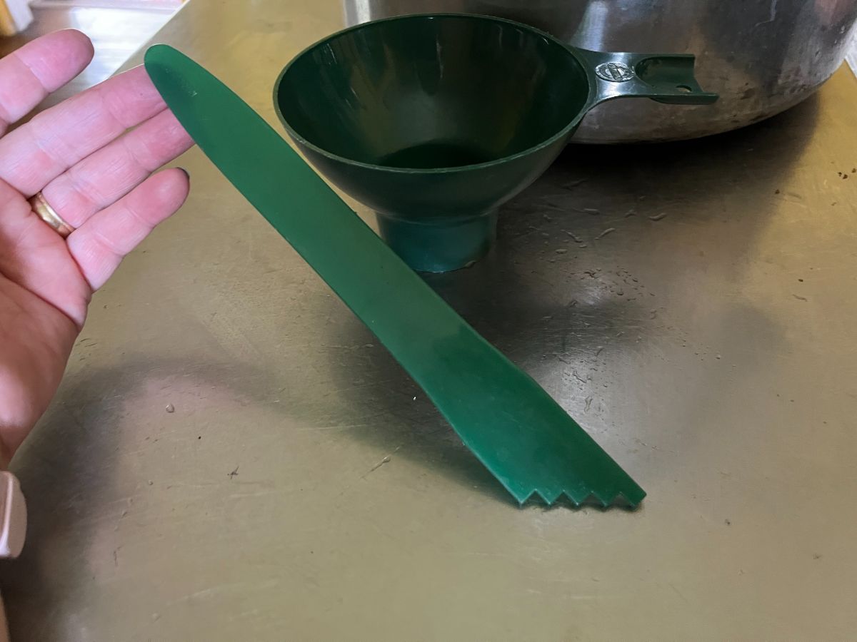 A small plastic spatula for removing air bubbles and measuring headspace