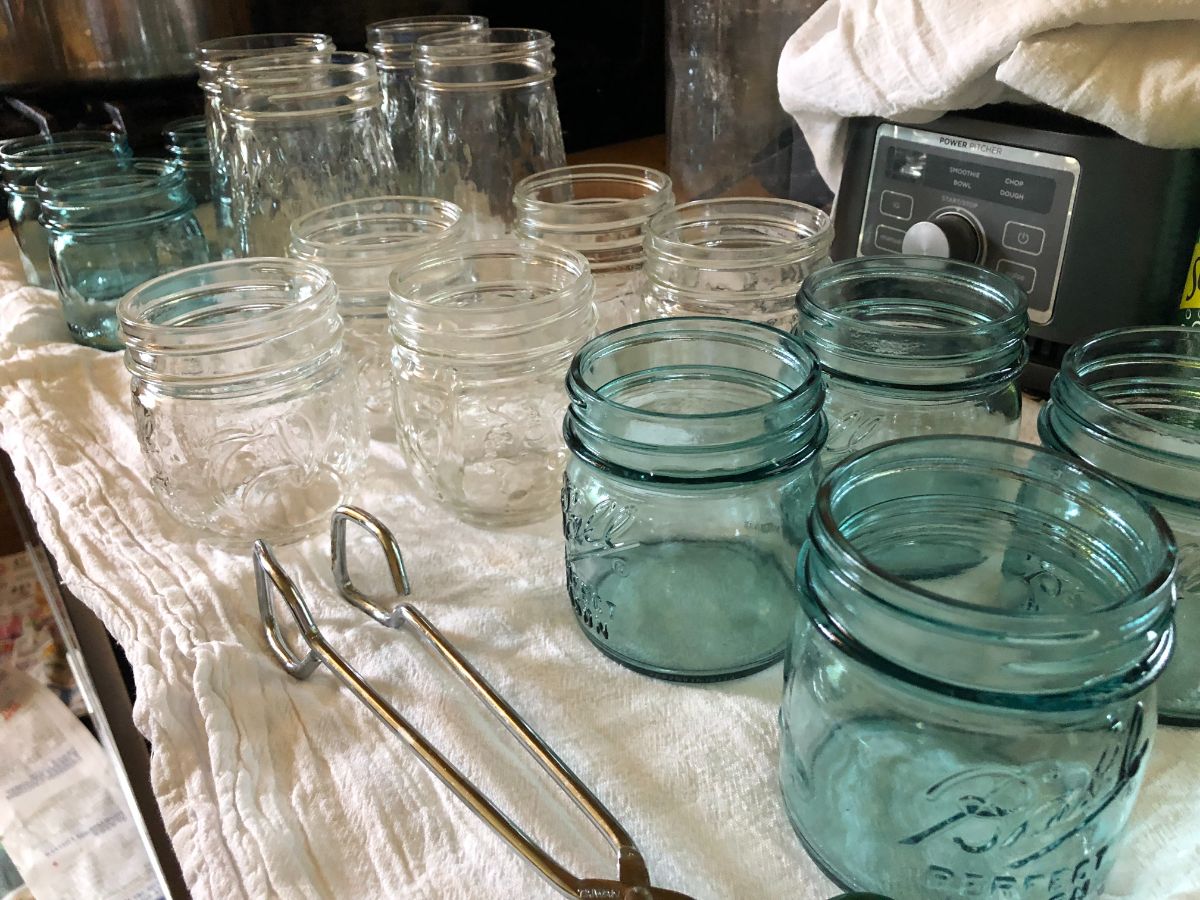 A set of tongs with clean, sterilized canning jars