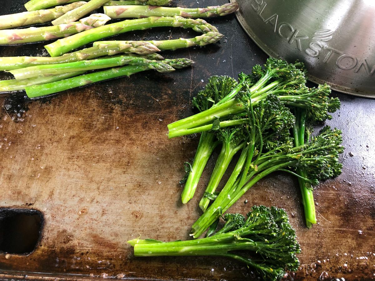 Vegetables being grilled on a flat grill