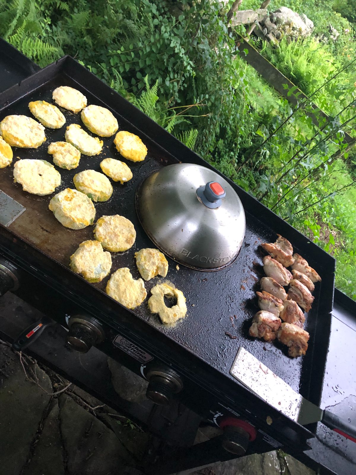 A flat top grill with vegetables cooking